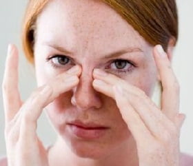 Woman with fingers on nose